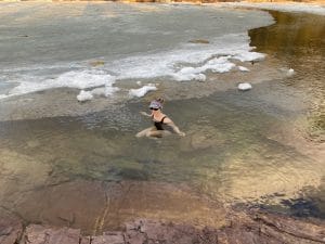 Woman wading in icy water in lake