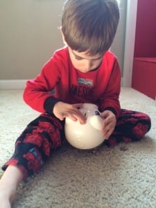 child putting money in a piggy bank