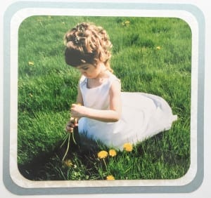 child in a flower girl dress picking flowers