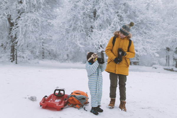 two kids drinking hot chocolate at one of our favorite Vermont sledding hills