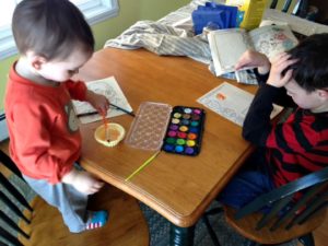 kids painting watercolors as mom waits for interruptions.