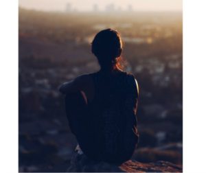 Thoughtful woman staring into the sunset. Introspective time: am I good enough?