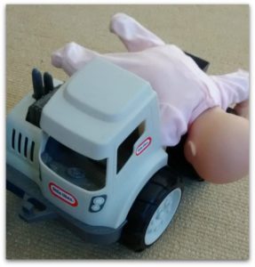 Pretending with a doll and a truck