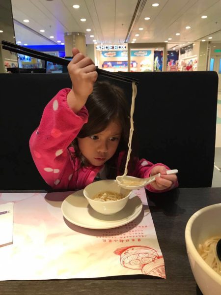 Bicultural and bilingual child eats ramen