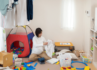My Life as a Stay at Home Mom with School Aged Children A stay-at-home mom folds clothing in a messy play room while her kids are not home.