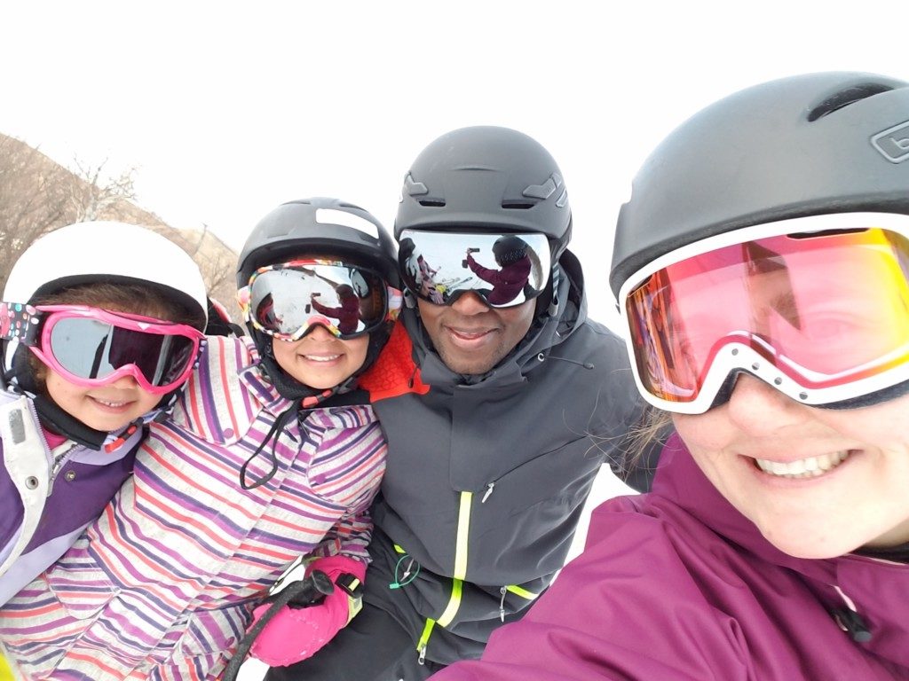 family in helmets, skiing