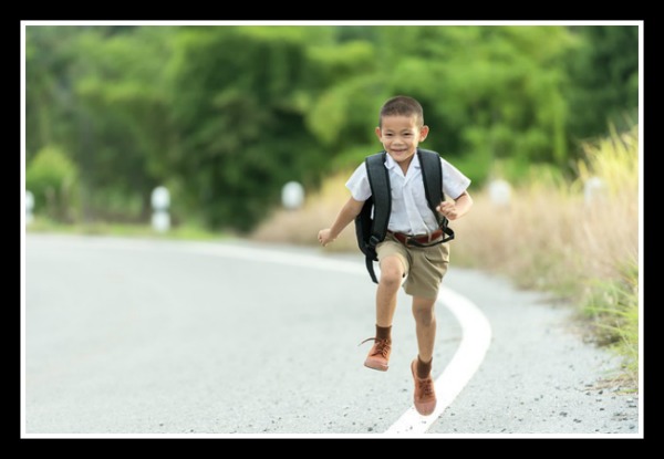 What Homeschooling Looks like in My Family child with a backpack skipping down the road