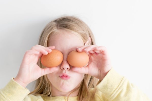 blonde daughter being silly holding eggs up to her eyes, girl, eggs