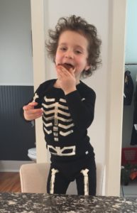 boy in costume eating sugar cookies