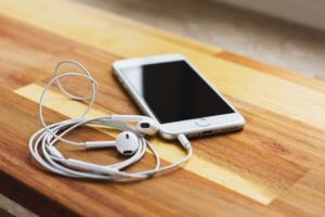 iPhone with headphones - women focused podcasts