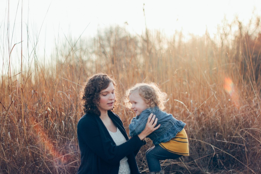 Mom playing with her toddler in a meadow not feeling any mom guilt