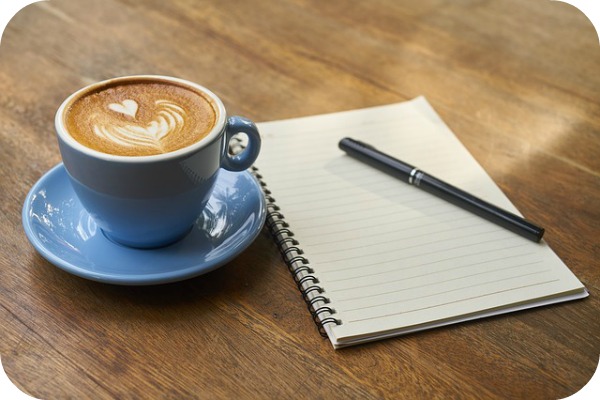 a notebook and a cup of coffee