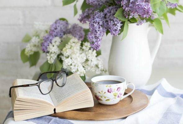 My Secret Mommy Fantasy is to Live Alone – No Children Allowed! glasses on a book, a cup of coffee, and flowers in the background