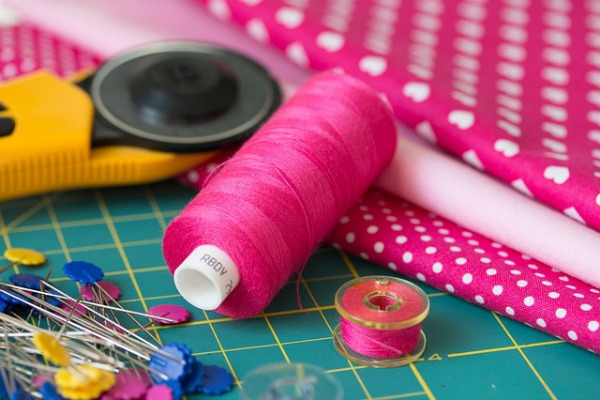 Sewing Skills – How to Remove Sleeves from a Dress sewing supplies including thread, fabric, and pins