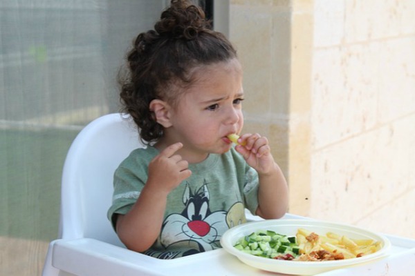 Picky Eaters – Dinner Solutions for the Entire Family young girl eating in a high chair