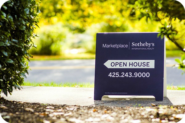 open house sign on a sidewalk