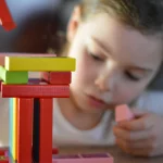 child playing with wooden block toys