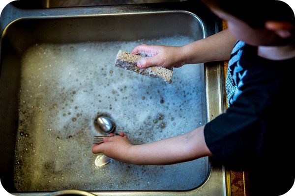 child washing dishes
