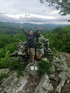 boys on a rock ledge in the mountains, hiking