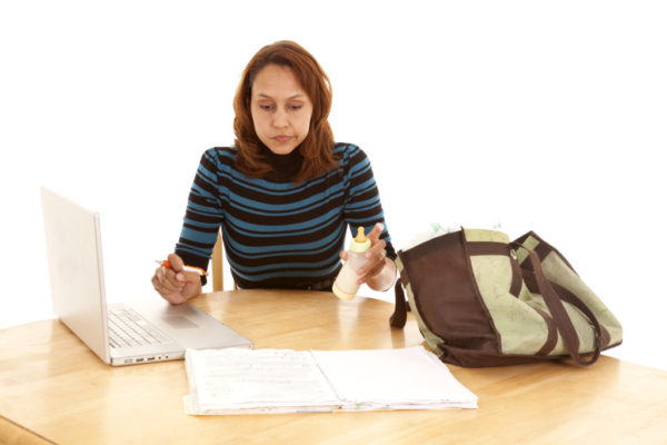 Surviving Mom Guilt after the Birth of My Second Child woman working, mom, computer, baby bottle, stressed