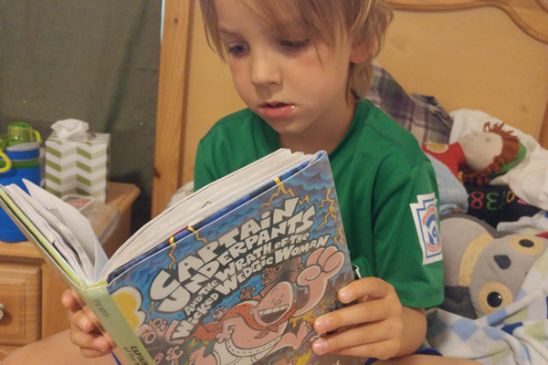 Books Parents Hate: In Defense of Captain Underpants and Others child reads captain underpants