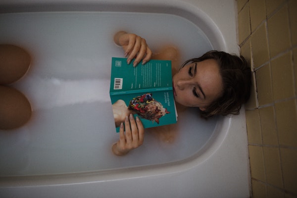 woman reading a book in the bathtub.