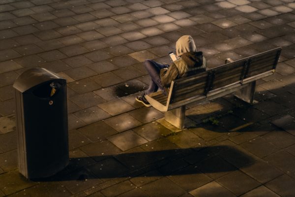 person on bench with cell phone