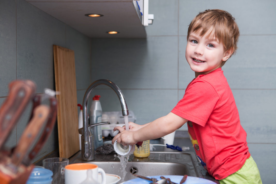 We Don’t Pay Our Kids for Doing Chores in Our Home boy washing dishes