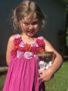 young girl smiling and holding bath bombs