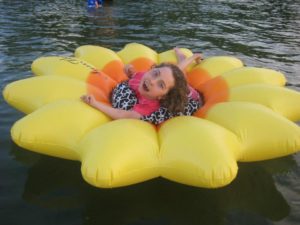 young girl with cerebral palsy on an inflatable flower raft