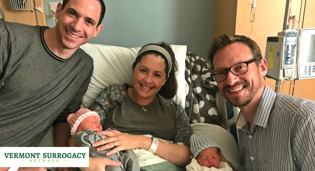 woman in a hospital bed with two newborn and men on either side of her.