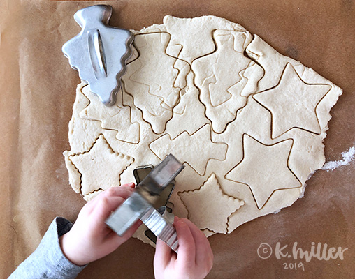 A child stamps cookie cutters into salt dough