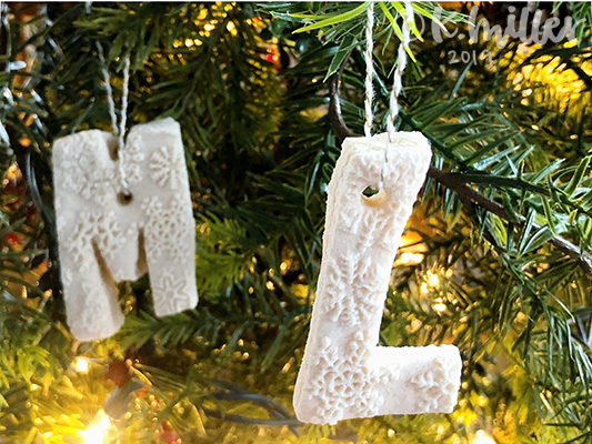 Two salt dough ornaments against greenery and lights