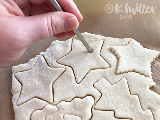 A straw creates holes in salt dough ornaments