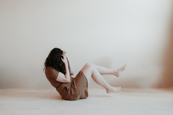 woman balanced on her bottom in a pre-fetal position