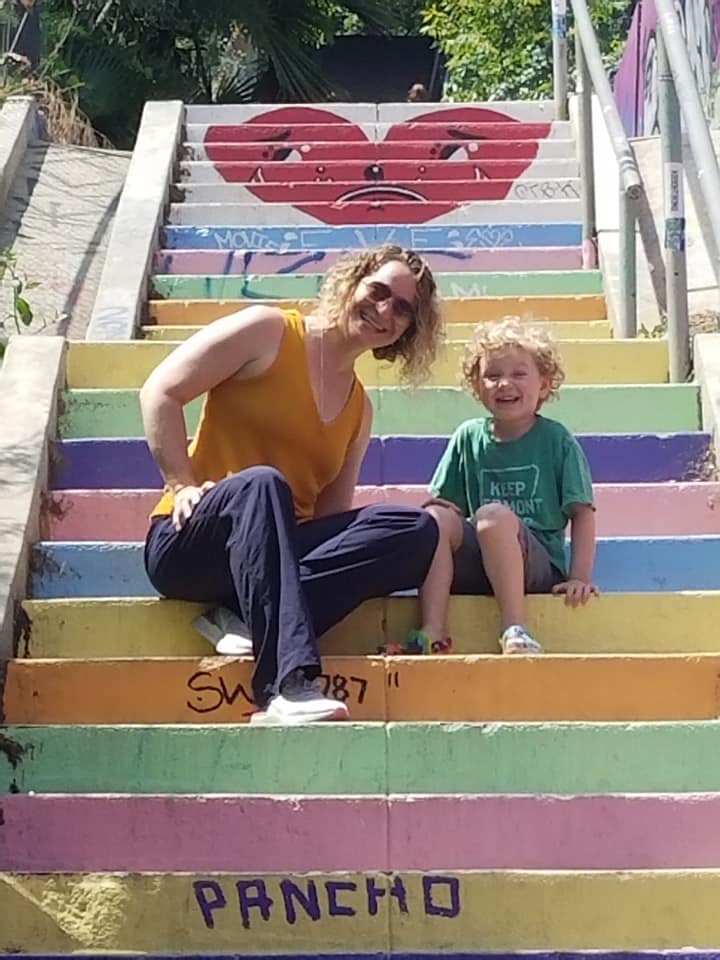 Mother and son on a rainbow painted stairwell