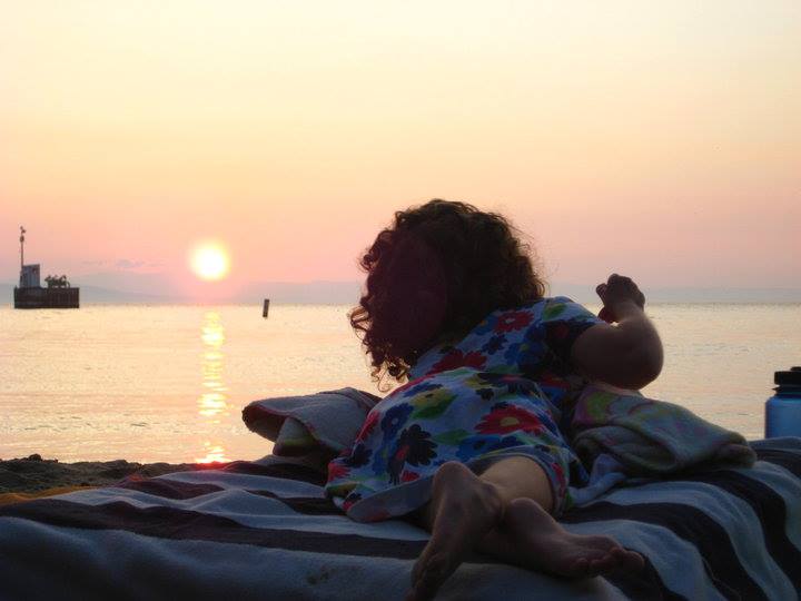 girl watching sunset while lying on a blanket