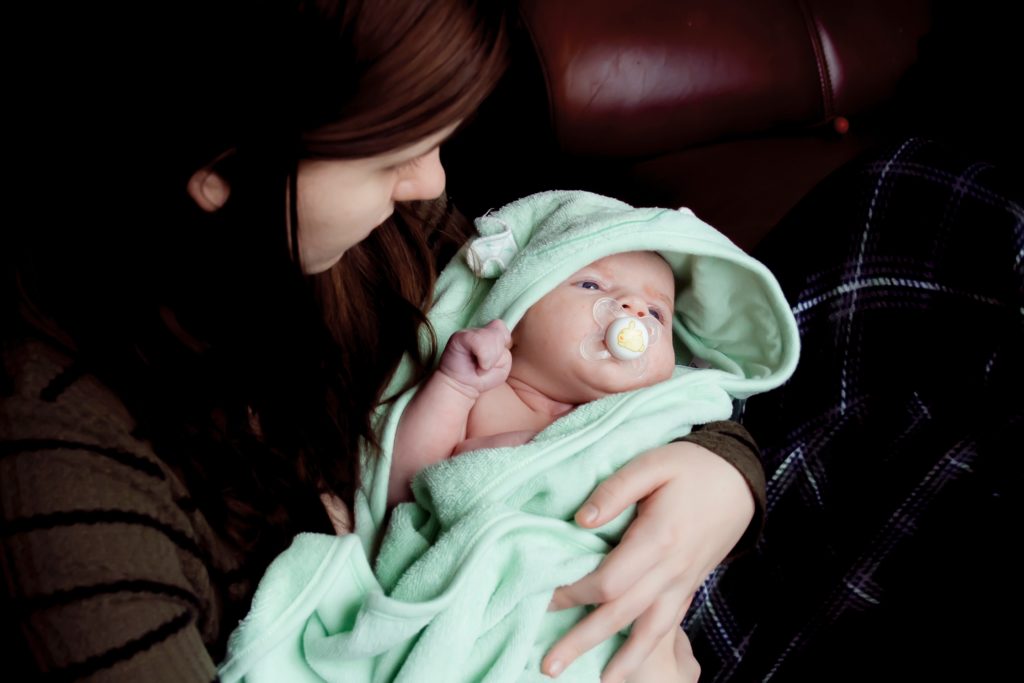 Woman holding a baby wrapped in a blanket