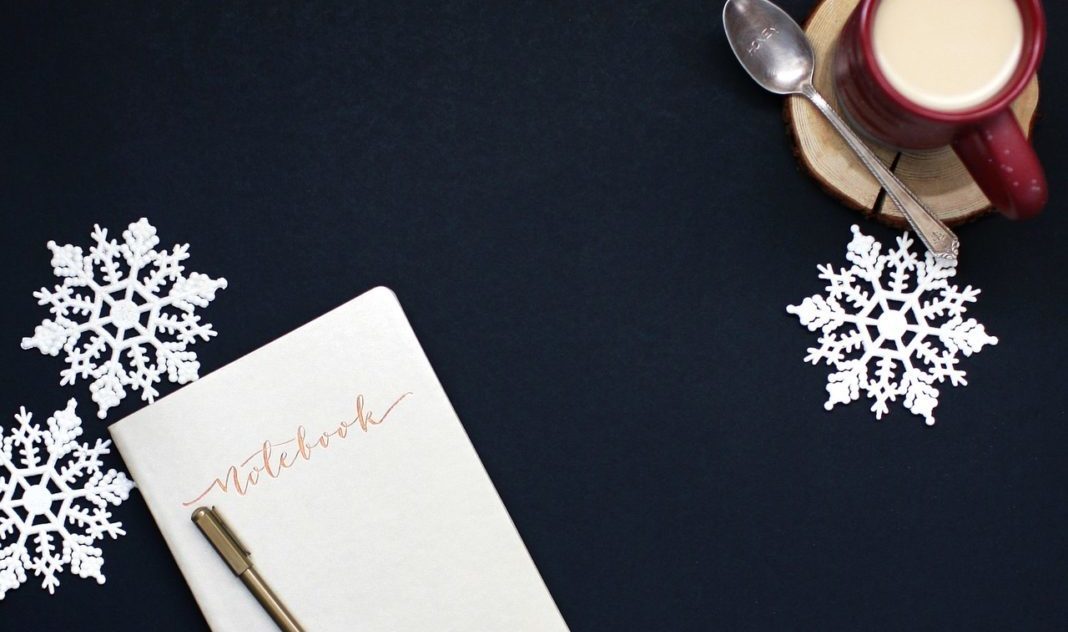 New Year Resolutions for Motherhood A notebook and coffee viewed from above