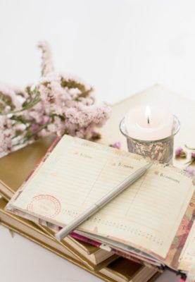 planner, pen, and lit candle