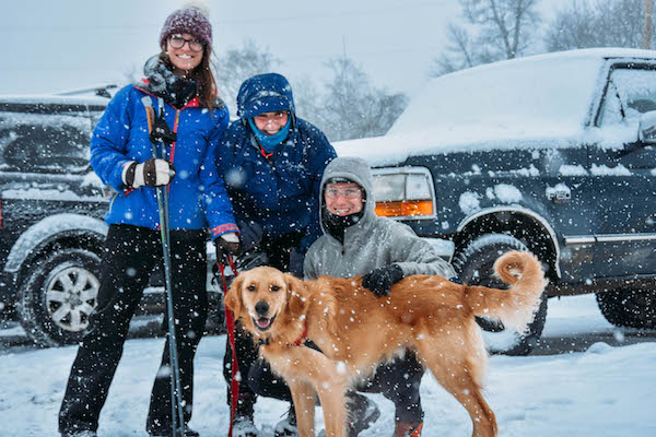 people and dog in the snow