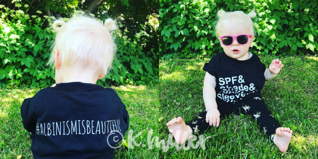 A toddler girl wearing sunglasses and a black t-shirt