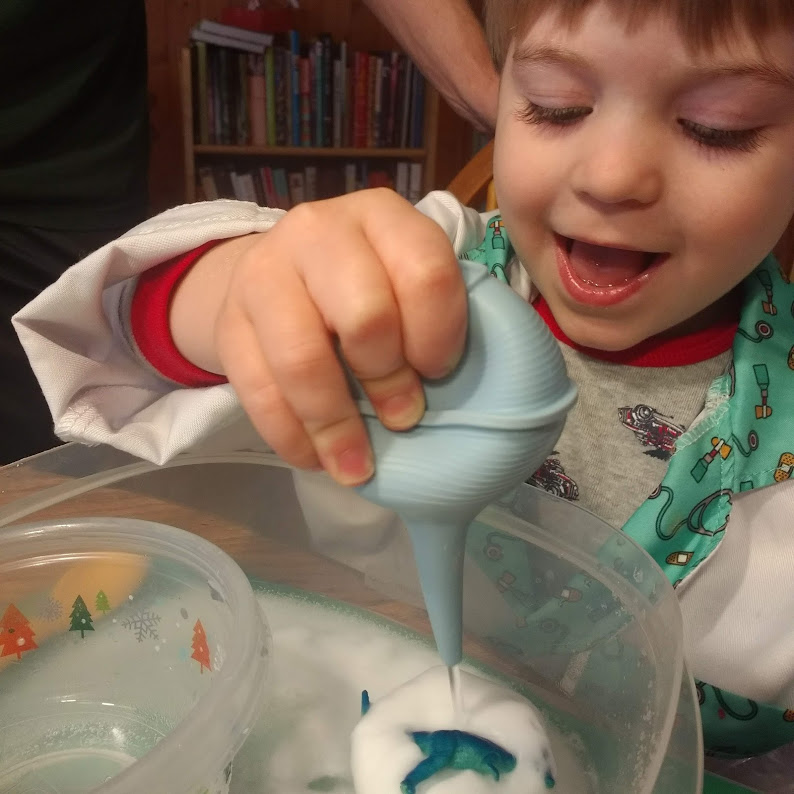 child drops vinegar onto baking soda balls