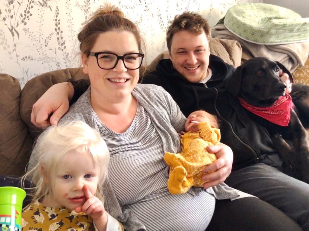 Family photo of toddler, mom, dad, infant, and dog