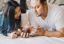 Tried and True Affordable Newborn Must-haves photo of couple looking down at their newborn