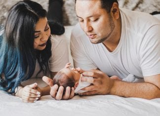 Tried and True Affordable Newborn Must-haves photo of couple looking down at their newborn