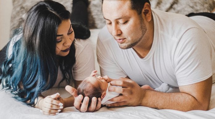 Tried and True Affordable Newborn Must-haves photo of couple looking down at their newborn
