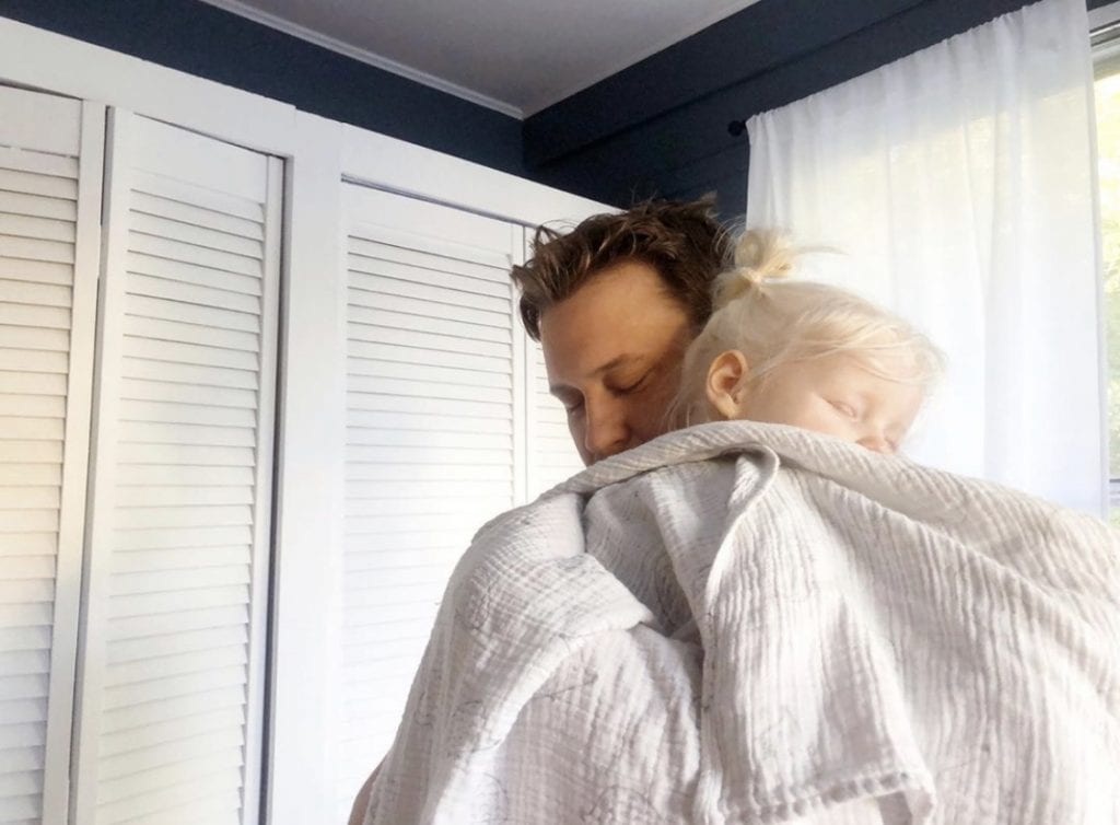 A man holding a sleeping baby