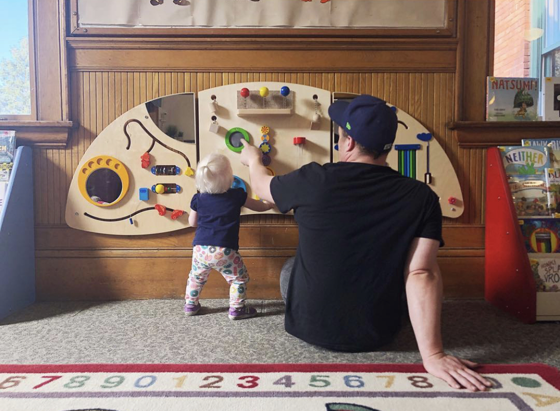 A toddler and man at the library