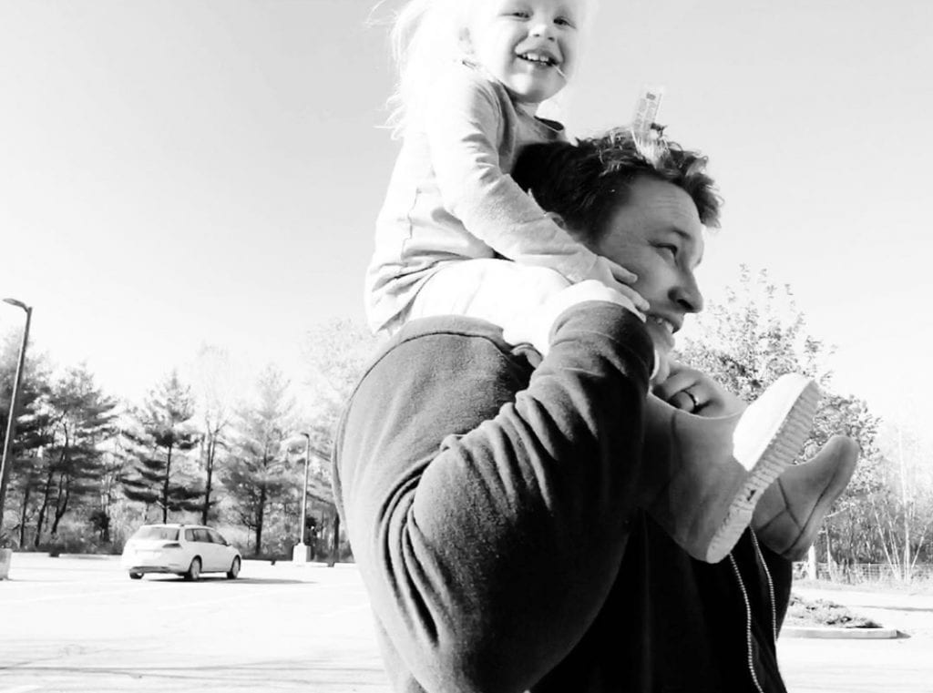 A man with a toddler on his shoulders